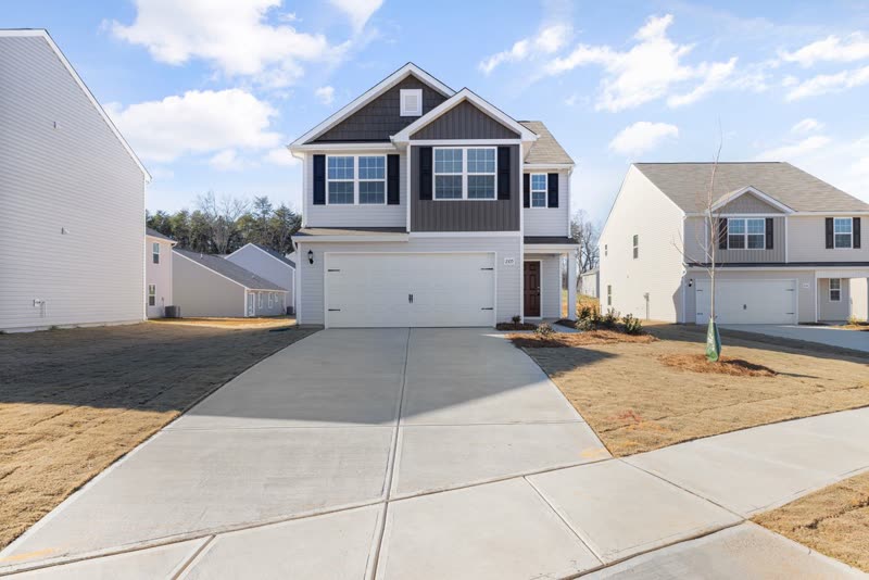 New concrete driveway leading to the garage of a two-storey house
